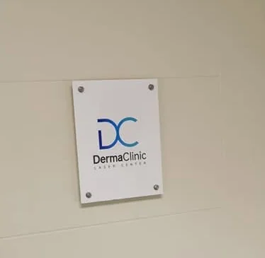 Placa de acrílico de DermaClinic Laser Center montada en la puerta de un consultorio