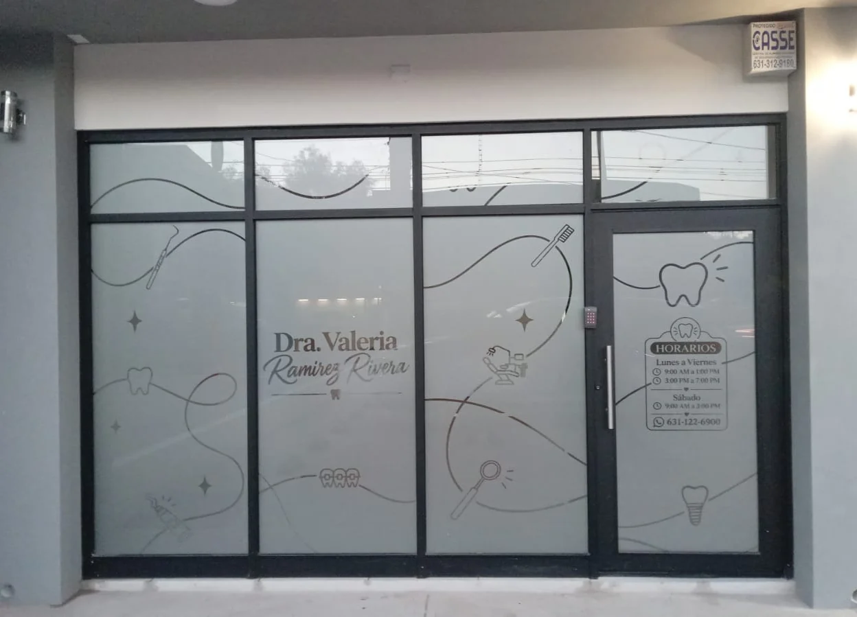 Fachada de cristal de un consultorio dental cubierta con vinil esmerilado y una ilustración de línea con instrumentos dentales