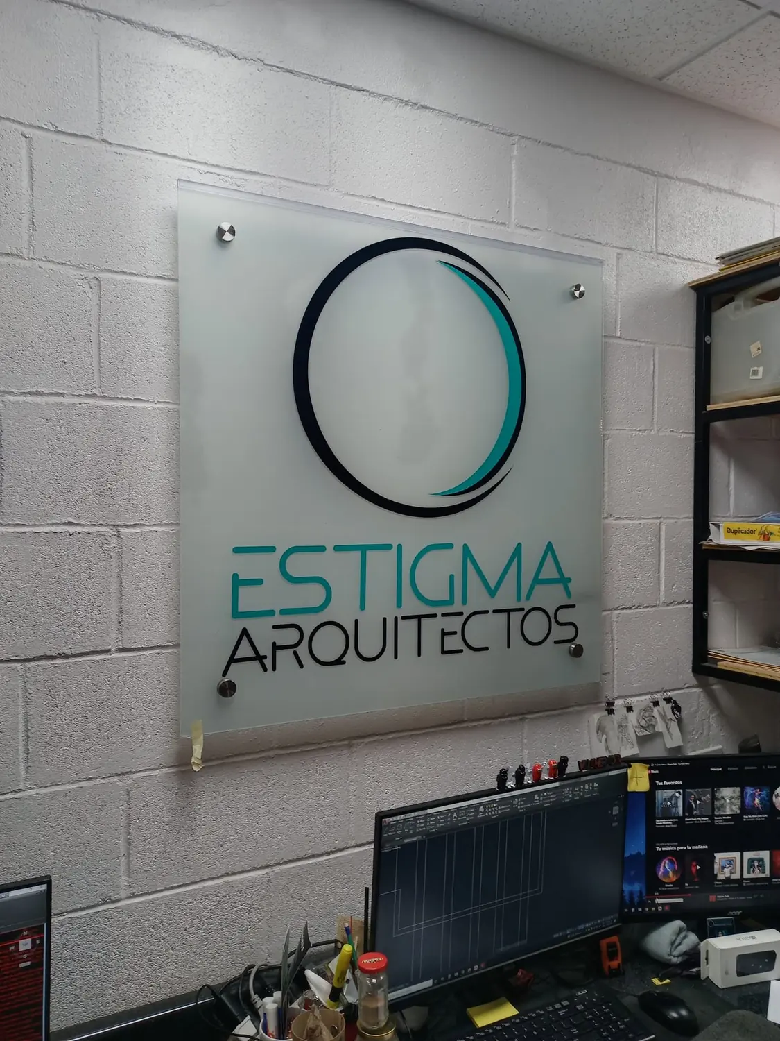 Placa de acrílico de Estigma Arquitectos montada con separadores sobre un muro de block