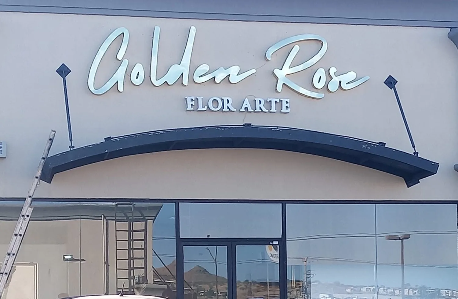 Fachada de Golden Rose Flor Arte de día con letras manuscritas recién instaladas