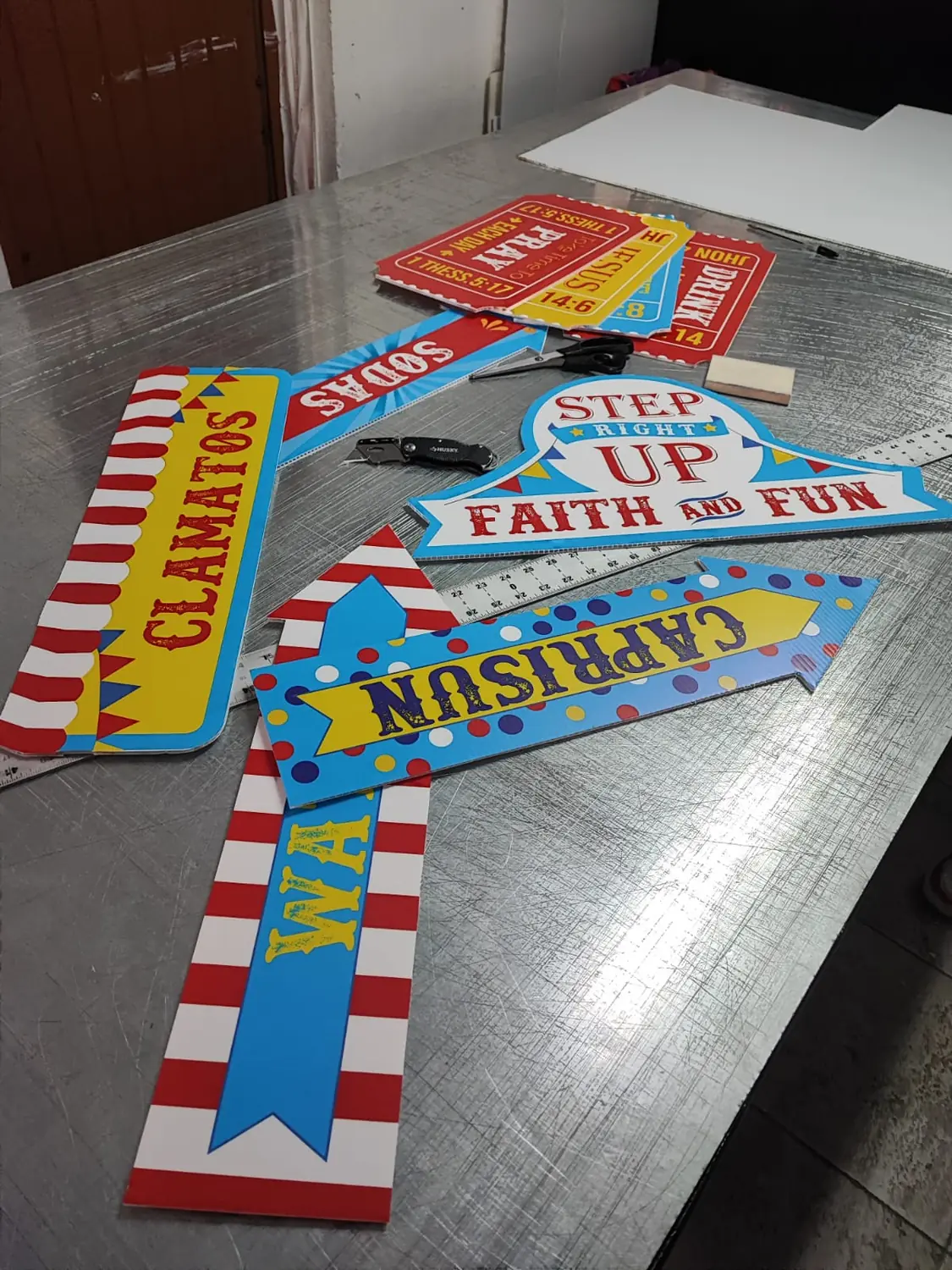 Letreros de coroplast con tema de circo recién recortados sobre la mesa de trabajo
