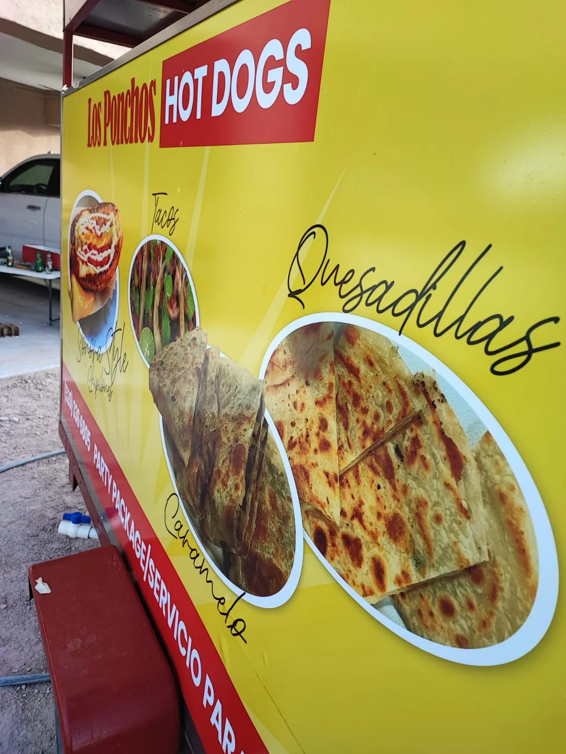 Remolque de comida forrado con vinil impreso amarillo con el menú de Los Ponchos Hot Dogs