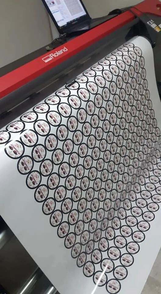 Pliego de stickers redondos siendo impresos y recortados en un plóter Roland